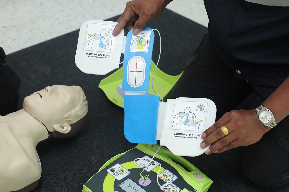 Demonstration of AED training pads being applied during a first aid and CPR training session.